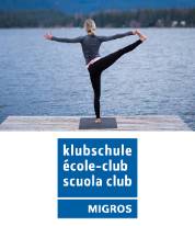 Frauen macht Yogaübung an einem See Klubschule (mit Logo)
