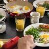 Herzhaftes Frühstück mit Spiegeleiern, Butter, Rucola und O-Saft
