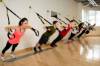 Gruppen-TRX-Training an einer Wand in einem Fitnessstudio