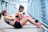 2 Hardcore Fitness-Frauen machen in einer Laufpause auf einer Brücke