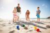 Familie spielt Boccia am Strand