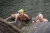 Drei fröhliche Winterschwimmer im Rhein an einer Treppe ins Wasser