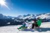 Familie mit zwei Kindern rodelt mit zwei Schlitten in Engadin-St-Moritz