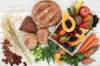 Kohlenhydrate in Lebensmittelform auf Tisch drapiert: Nüsse, Getreideprodukte, Obst und Gemüse
