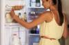 Junge Frau am offenen Kühlschrank