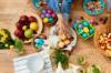 Tisch mit Brötchen, bunten Eiern, Salat und Obst