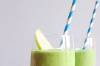 Zwei grüne Joghurt-Avocado-Skake mit Apfelstück und Blau-weissen Strohhalmen
