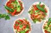 Vier ungerollte Tortillas mit Tomatensosse, Pepperoni, Kräutern und Fleisch belegt