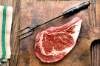Perfekt marmoriertes Rindfleisch-Steak auf altem Holzbrett mit Fleischgabel