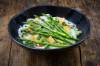 Schwarzes Bowl mit grünem Spargel, Tofu und Reisbandnundeln