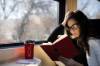 Frau liest im Zug ein Buch