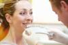 Zahnarzt prüft bei Patientin die Farbe ihrer Zähne