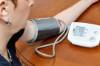 Frau misst ihren Blutdruck mit einem Blutdruckgerät