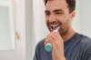 Mann beim Zähneputzen mit einer elektrischen Zahnbürste