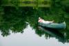 Mann liegt in einem Kanu auf dem Wasser und schläft