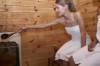 Frau in der Sauna mache den Aufguss