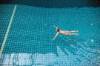 Frau schwimmt alleine im Schwimmbecken