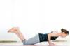 Frau auf Yogamatte macht Brust- Schultertraining